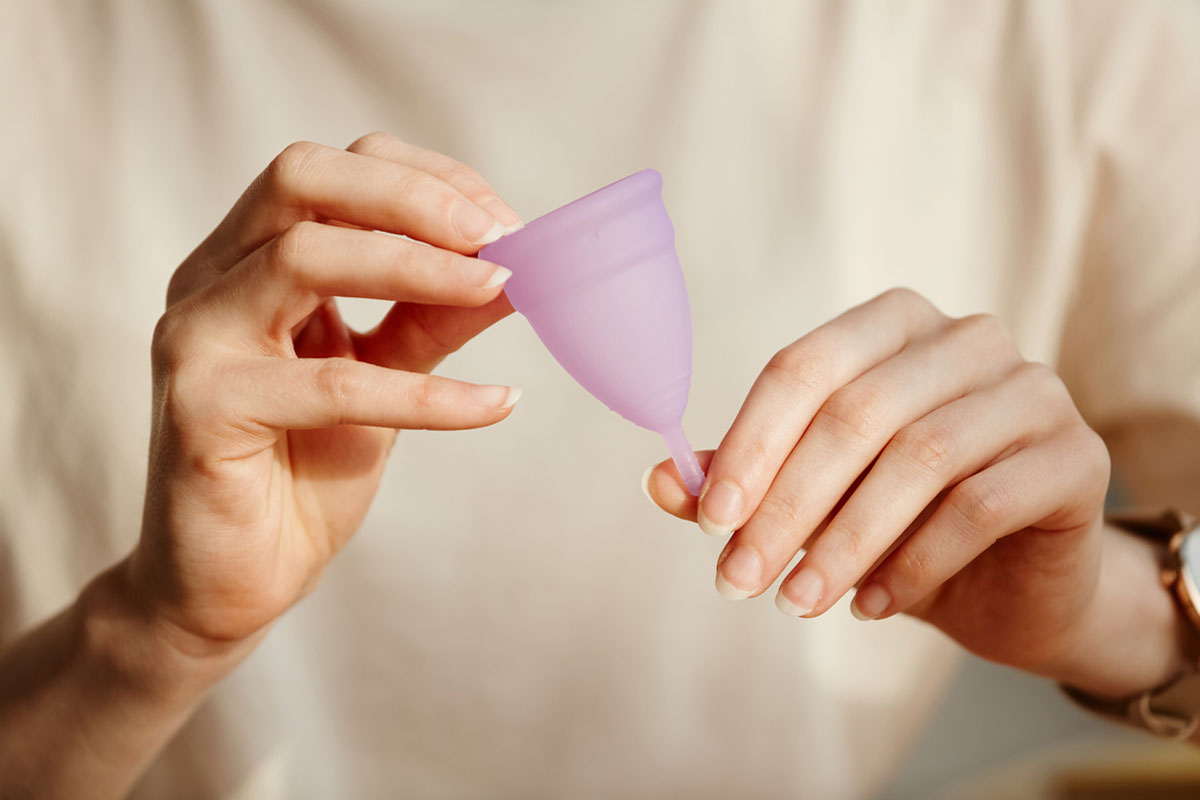 A lady holding a menstrual cup